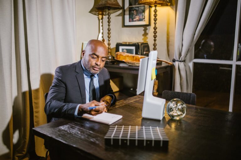 Man in Black Suit Jacket Sitting on Chair